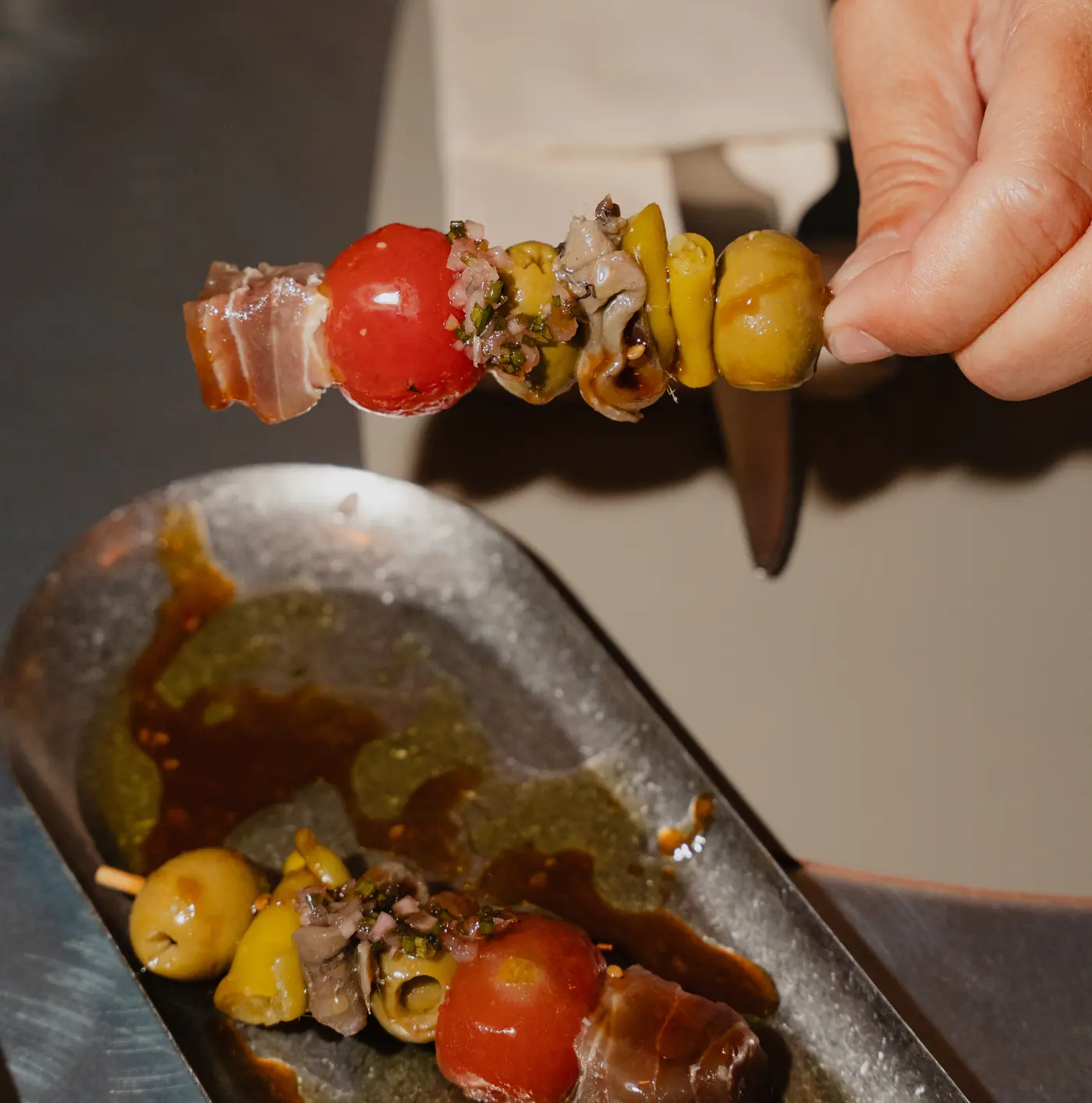 Una gilda de cerca: salazón, tomate, piparra y aceituna, sobre su bandeja